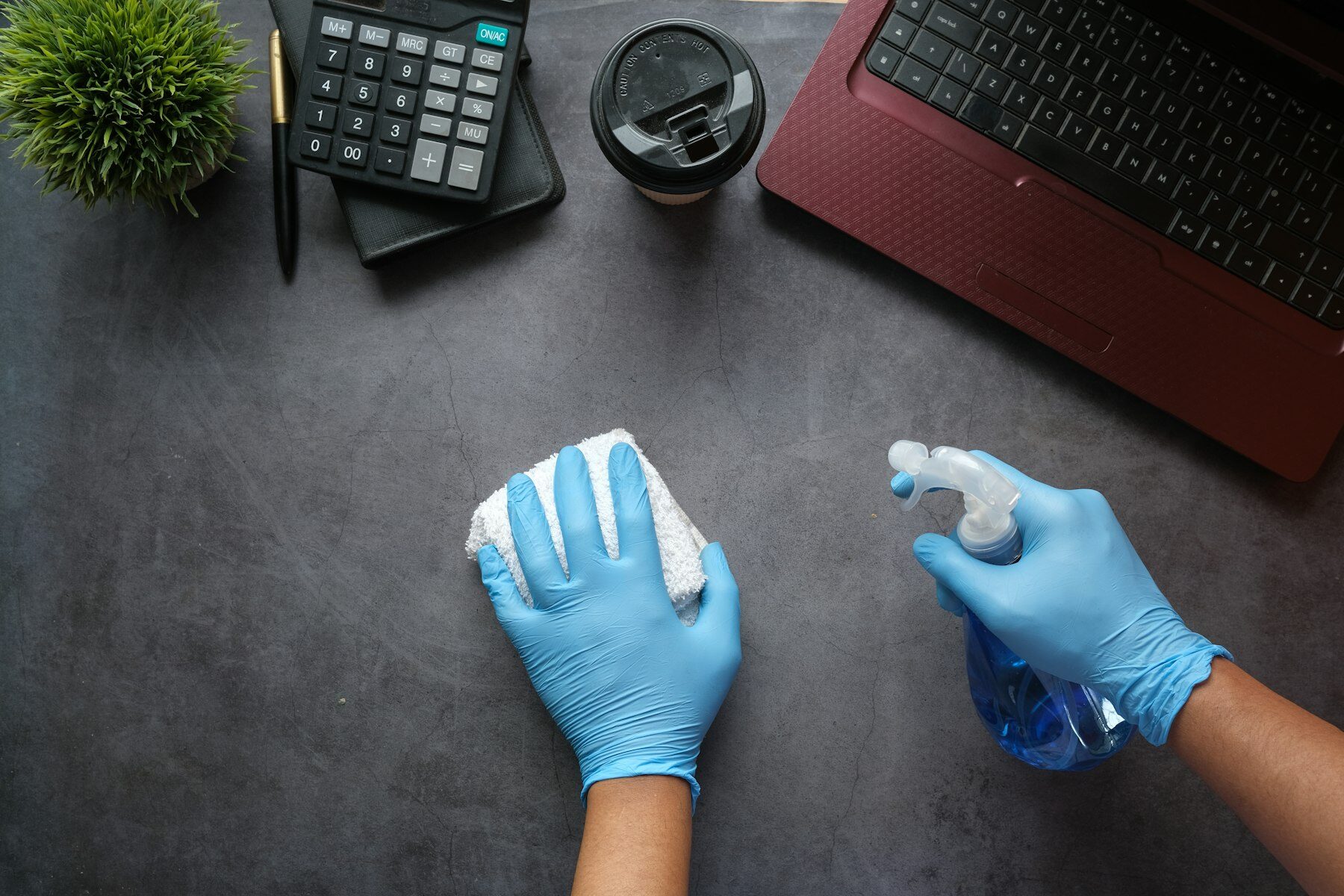 Schoonmaakmedewerker reinigt een bureau